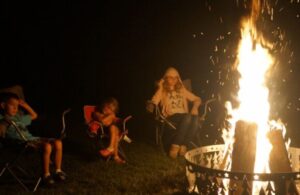 Kids Sitting Around a Fox River Fire Ring with a Fire
