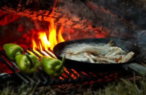 Fish and Peppers Cooking Over a Fire
