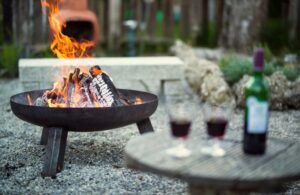 Wine Bottle and Glasses on a Table with Fire in Background